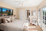 A spacious bedroom with a queen bed and walk-in closet and direct access to the outside deck